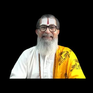 An astrologer wearing traditional yellow attire with a white beard and glasses.